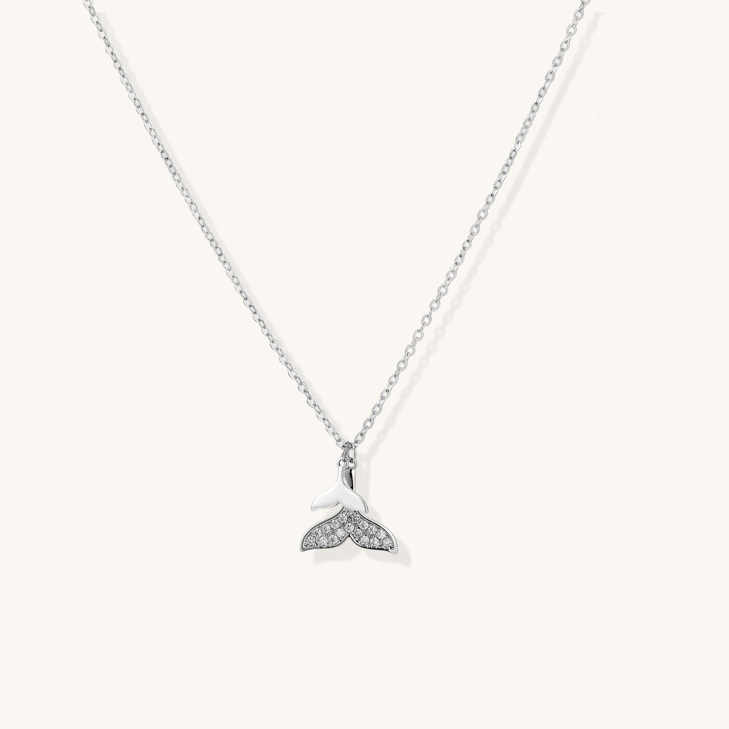 Delicate 14K gold-plated whale tail pendant necklace with sparkling crystal details on fine chain against white background.