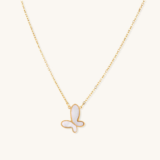 Delicate gold butterfly necklace with white mother of pearl wings on fine chain, displayed on neutral background.